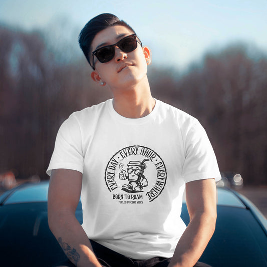 Person wearing a white t-shirt with a vintage stamp graphic design outdoors