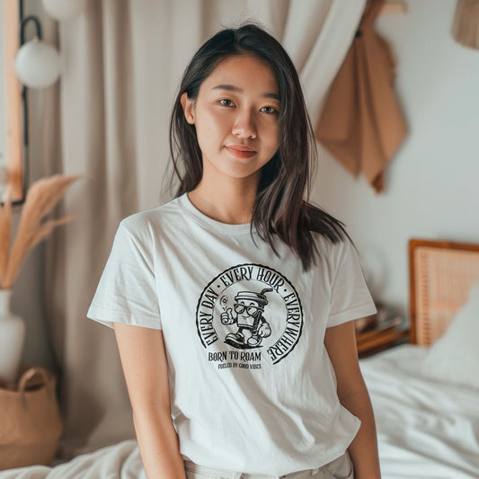 Woman wearing a white t-shirt with a black vintage stamp design in a bedroom setting.