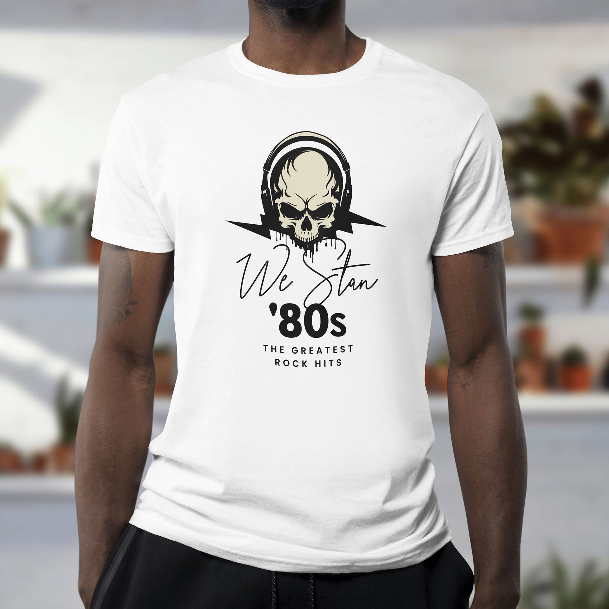 A man wearing a white t-shirt with a skull design and text on a plain background on the front of the T-shirt